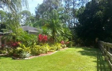 Lush vegetation surrounds private screened pool and patio.